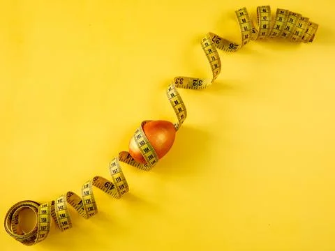 Golden easter egg and yellow tape measure yellow background. Healthy nutritio Stock Photos
