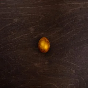 Golden easter egg on wood 스톡 사진
