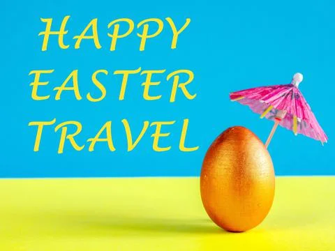 Golden Easter egg on yellow blue background under sun umbrella. Spring travel Stock Photos
