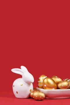 Golden Easter eggs painted with stripes and dots and bunny on red background Foto stock