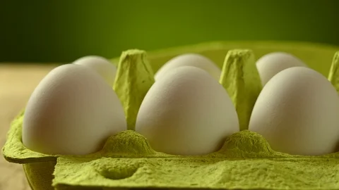Golden egg appears in a package of white eggs Stock Footage 121971474