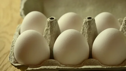 Golden egg appears in a package of white eggs Stock Footage 121971614