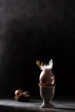Golden egg. Easter gold egg wth feather above. Easter egg decoration with pat Stock Photos
