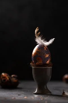 Golden egg. Easter gold egg wth feather above. Easter egg decoration with pat Stock Photos
