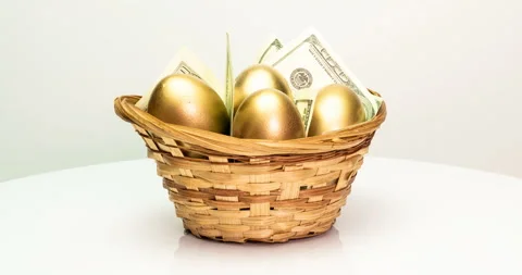 Golden eggs and dollars in a basket on a white background. Golden eggs close-up Stock Footage 129801583