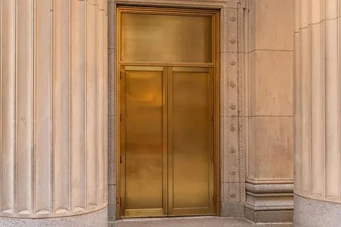 Golden elevator door in a classical stone building Stock-Fotos