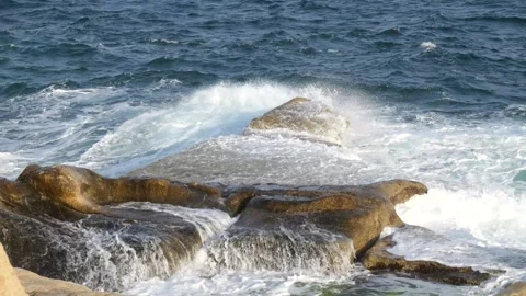 Golden evening light warms limestone rock formations calm sea stretching along Stock Footage 341807680