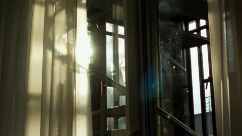 Golden evening sun shining through translucent drapery beside window frame Stock Footage 344356885