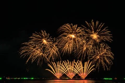 Golden Fireworks Display Exploding Over Dark Water Horizon Wide Shot Stock Photos