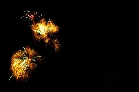 Golden fireworks exploding in dark night sky creating festive celebration Stock Photos