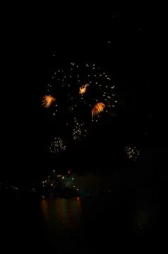 Golden Fireworks Exploding in Night Sky over River Festival Celebration Foto stock
