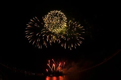 Golden Fireworks Exploding in Night Sky over River Festival Celebration Foto stock