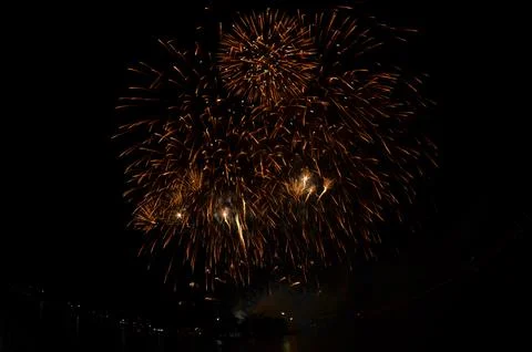 Golden Fireworks Exploding in Night Sky over River Festival Celebration Stock Photos