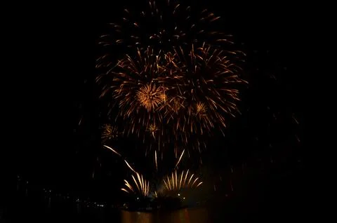 Golden Fireworks Exploding in Night Sky over River Festival Celebration Foto stock