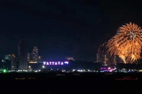Golden Fireworks Exploding Over The Illuminated Pattaya City Coastline Nigh.. Stockfoto's