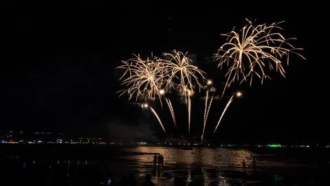 Golden Fireworks Exploding Over Ocean Beach With Crowd At Night In Pattaya .. Stock Photos