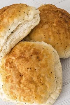 Golden, flaky bread rolls with black pepper, fresh from oven 스톡 사진