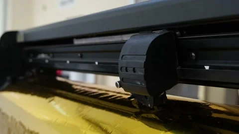 Golden foil cutting plotter machine. Vinyl cutter plotter machine and moving cut Stock Footage 146033033