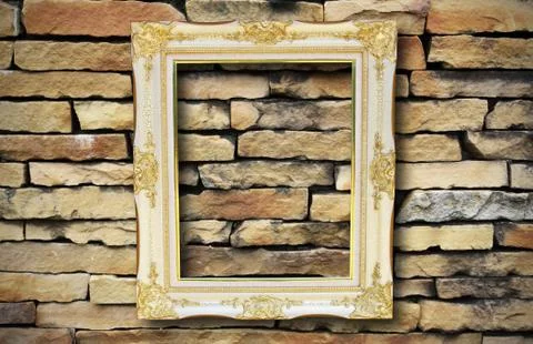 Golden frame on old brick wall Stock Photos
