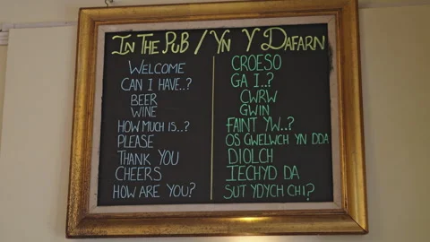 A golden framed chalkboard with basic phrases translated into Welsh Video stock 245327899
