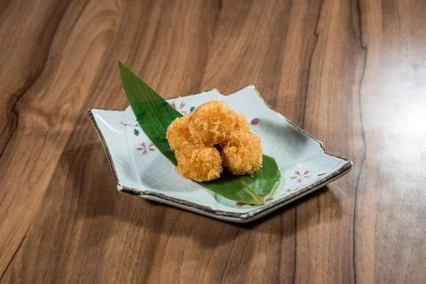 Golden fried bites on patterned plate Stock Photos