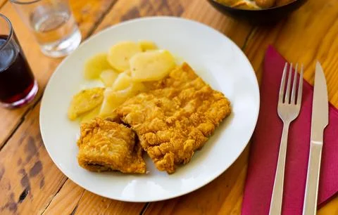 Golden fried cod fillet with boiled sliced potatoes Stock Photos