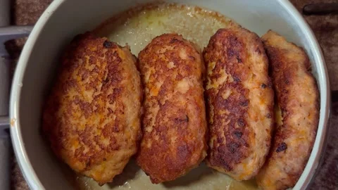 Golden fried meat cutlets in a white pan with oil on a stove Stock-Footage 341510512