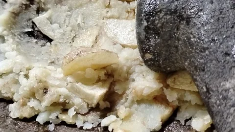 Golden fried potatoes placed in a stone mortar before being mashed by hand Stock Footage 336392397