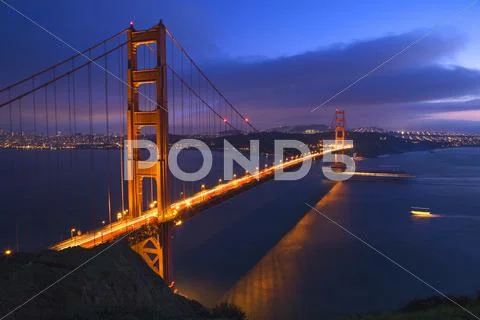 Golden gate bridge at night with boats san francisco california Stock Photos