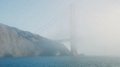 Golden Gate Bridge obscured by fast moving early morning fog in Pacific Ocean Stock Footage 242829096