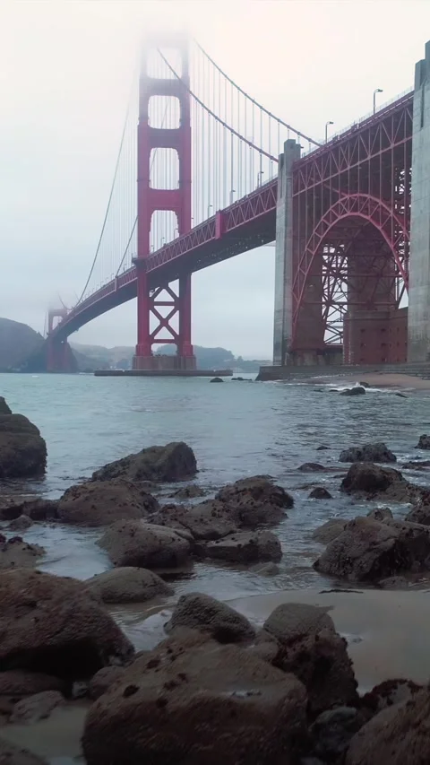 Golden Gate Bridge view from a rocky beach on a foggy day. Stock Footage 313373440