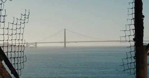 Golden gate framed between broken fence Stock Footage 260572508