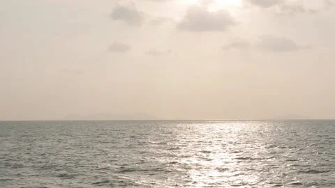 Golden glare of the setting sun on the waves in the open sea. Reflections in the Stock Footage 312109758
