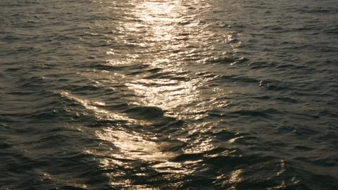 Golden glare of the setting sun on the waves in the open sea. Reflections in the Stock Footage 312110251