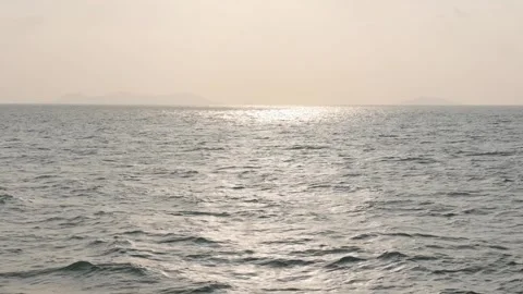 Golden glare of the setting sun on the waves in the open sea. Reflections in the Stock Footage 314119408