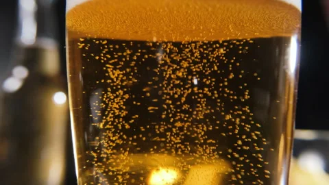 Golden glow of bubbles in a refreshing beer drink Stock Footage 296215608