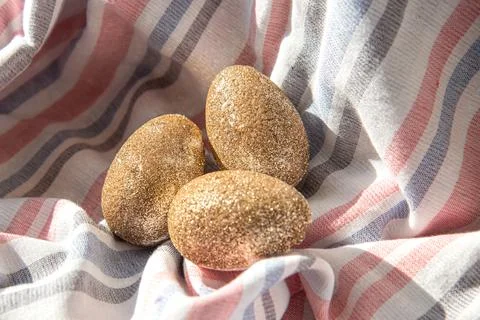 Golden handmade painted Easter eggs on a textile background. Minimal concept Stock Photos