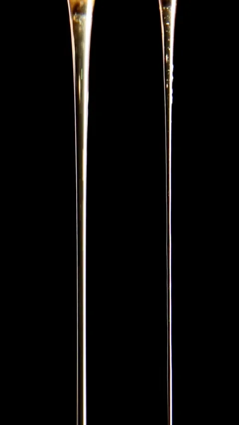 Golden honey flows in two streams on a black background. ASMR video. Stock Footage 246532399