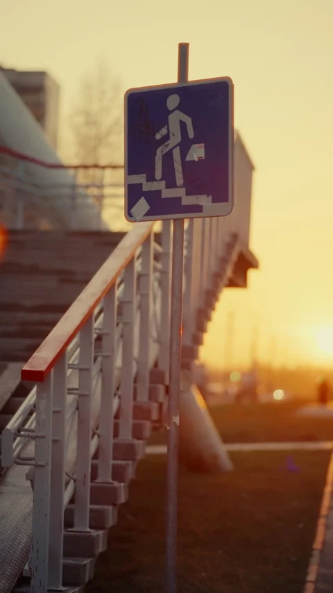 Golden hour casting warm light on pedestrian sign, highlighting architectural Stock Footage 308442452