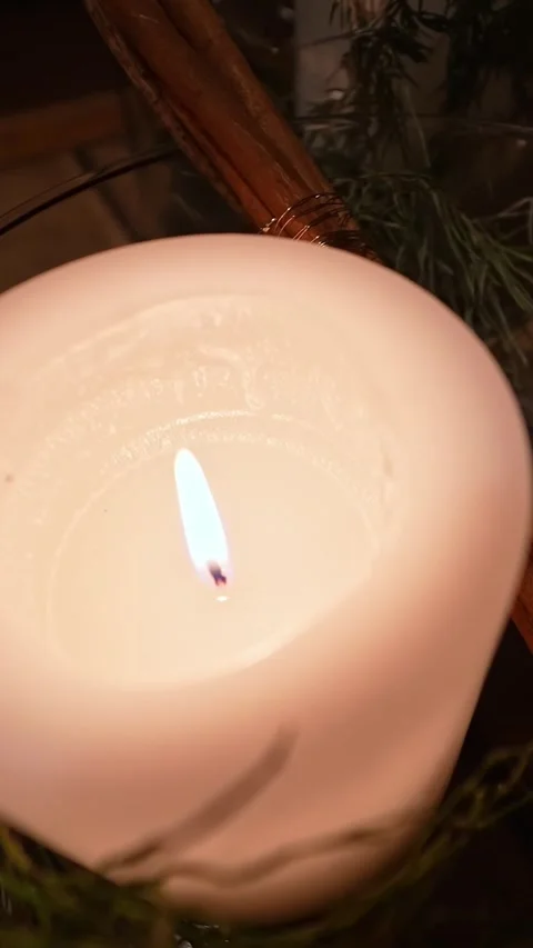Golden-hour close-up of a lit white candle in a glass bowl with rosemary and Stock Footage 327892188