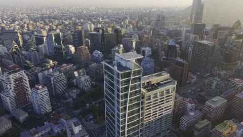 Golden hour drone orbit over Apoquindo tower and Las Condes skyline Santiago Vídeos de archivo 334683119