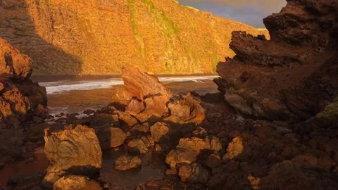 Golden hour envelops rugged cliffs and crashing waves on Canary Islands Stock Footage 308418870