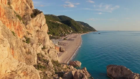 Golden Hour Flight Along Dramatic Coastal Cliffs and Secluded Beach Stock-Footage 336514562