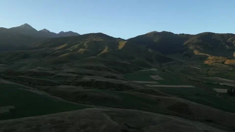 Golden hour light casting shadows on Kyrgyzstan mountains Video stock 345213005