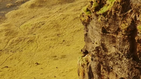 Golden Hour Light on a Rugged Cliff and Grassy Hillside Landscape Stock Footage 320198854