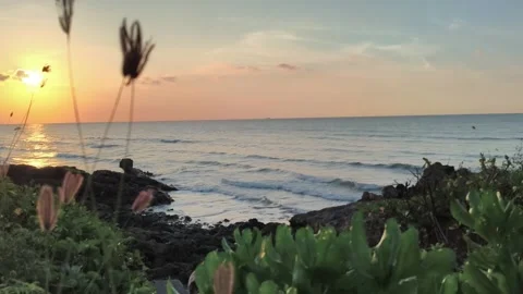 Golden Hour Ocean Sunset over Rocky Coastline with Rolling Waves Stock Footage 340489676