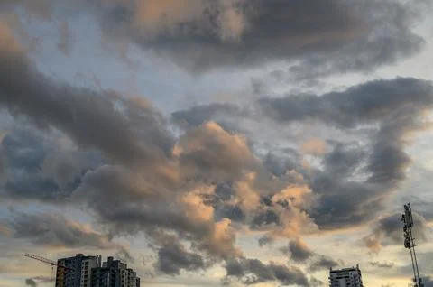 Golden Hour Sky with Dramatic Layered Clouds, Warm Orange and Cool Grey Con.. Stock Photos