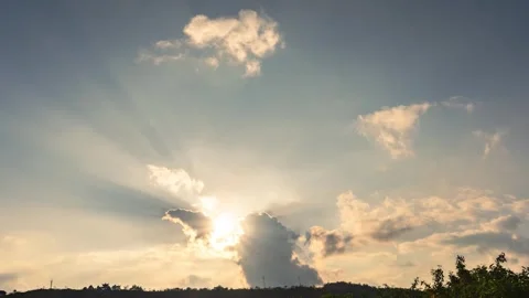 Golden Hour Sun Rays Breaking Through Clouds Over A Silhouetted Landscape Stock Footage 341957543