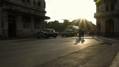 Golden hour sun rays, long shadows, classic American 1950's Vintage car street Stock Footage 99843175
