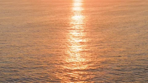 Golden hour sun reflection on shimmering ocean water texture 動画素材 338196842
